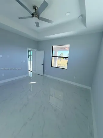 a bedroom with a bed and a flat tv screen on dresser