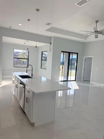 a kitchen with stainless steel appliances granite countertop a sink and a stove top oven