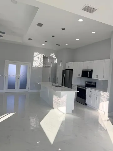a living room with furniture a flat screen tv and kitchen view