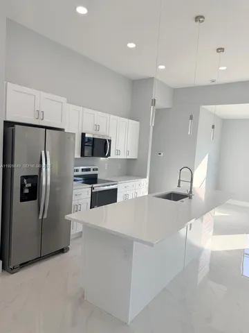 a kitchen with stainless steel appliances a refrigerator sink and stove