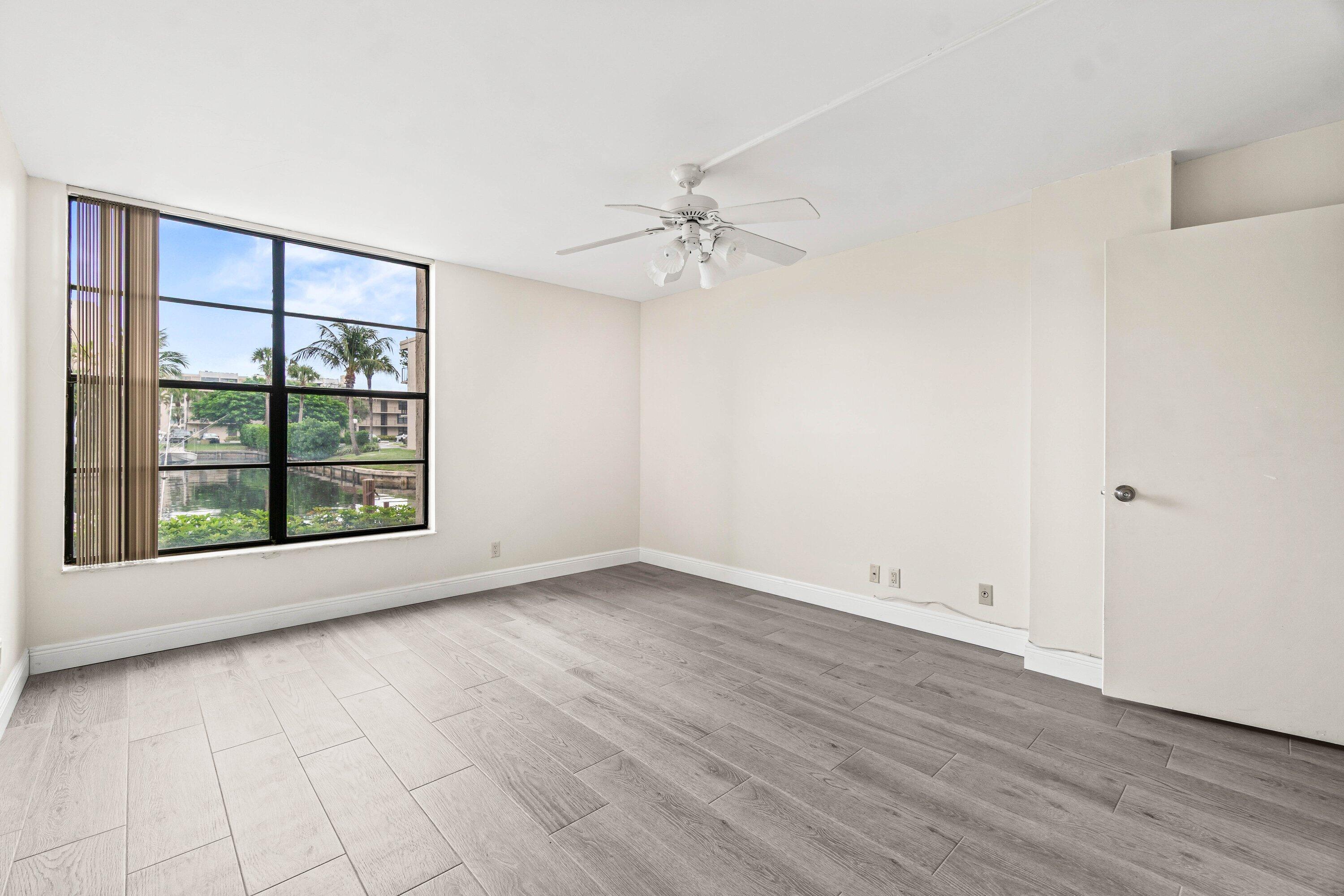 17 Royal Palm Way, Unit 103 Boca Raton, FL 33432 - Photo 17 of 28 an empty room with wooden floor and windows