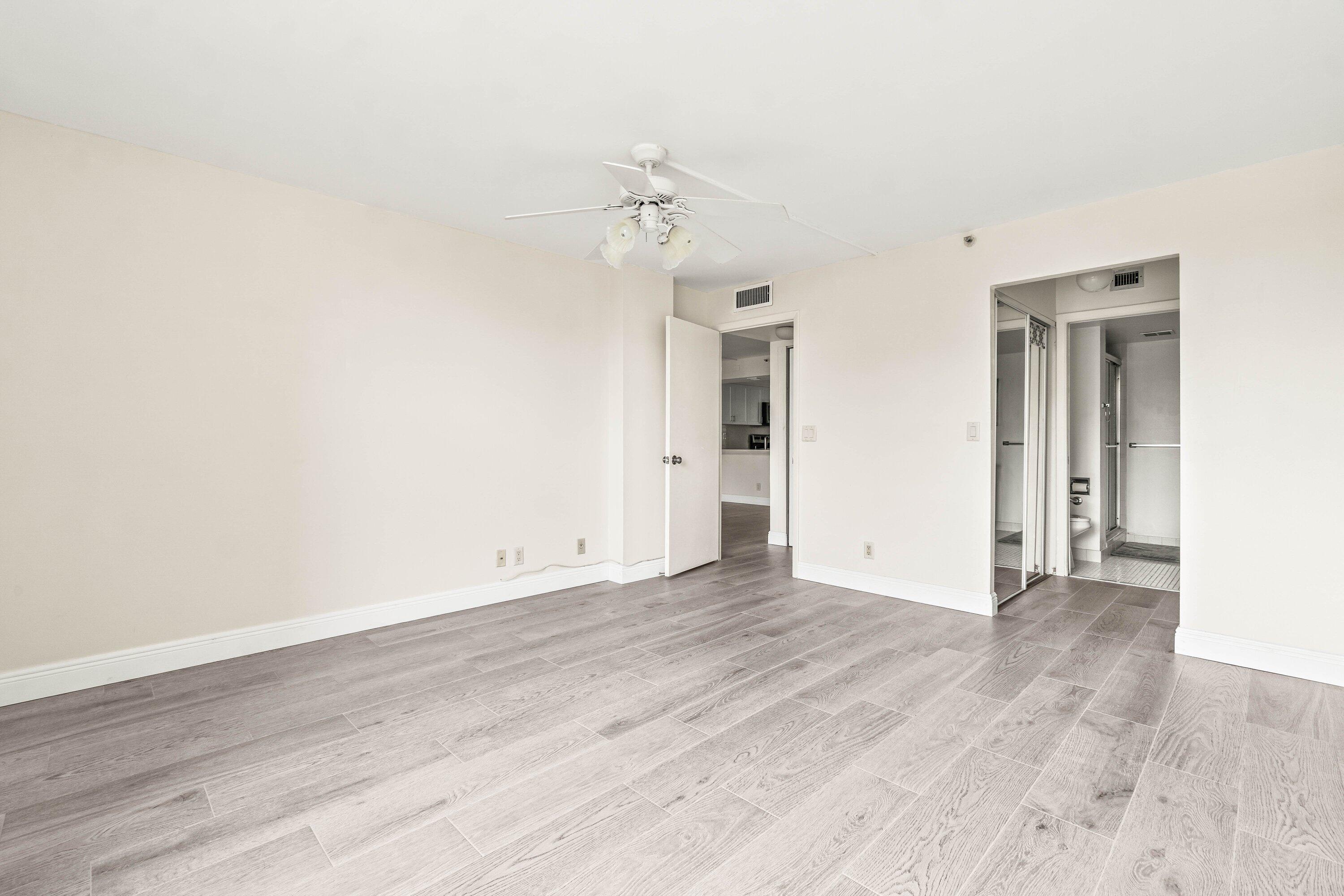 17 Royal Palm Way, Unit 103 Boca Raton, FL 33432 - Photo 19 of 28 an empty room with wooden floor ceiling fan and windows