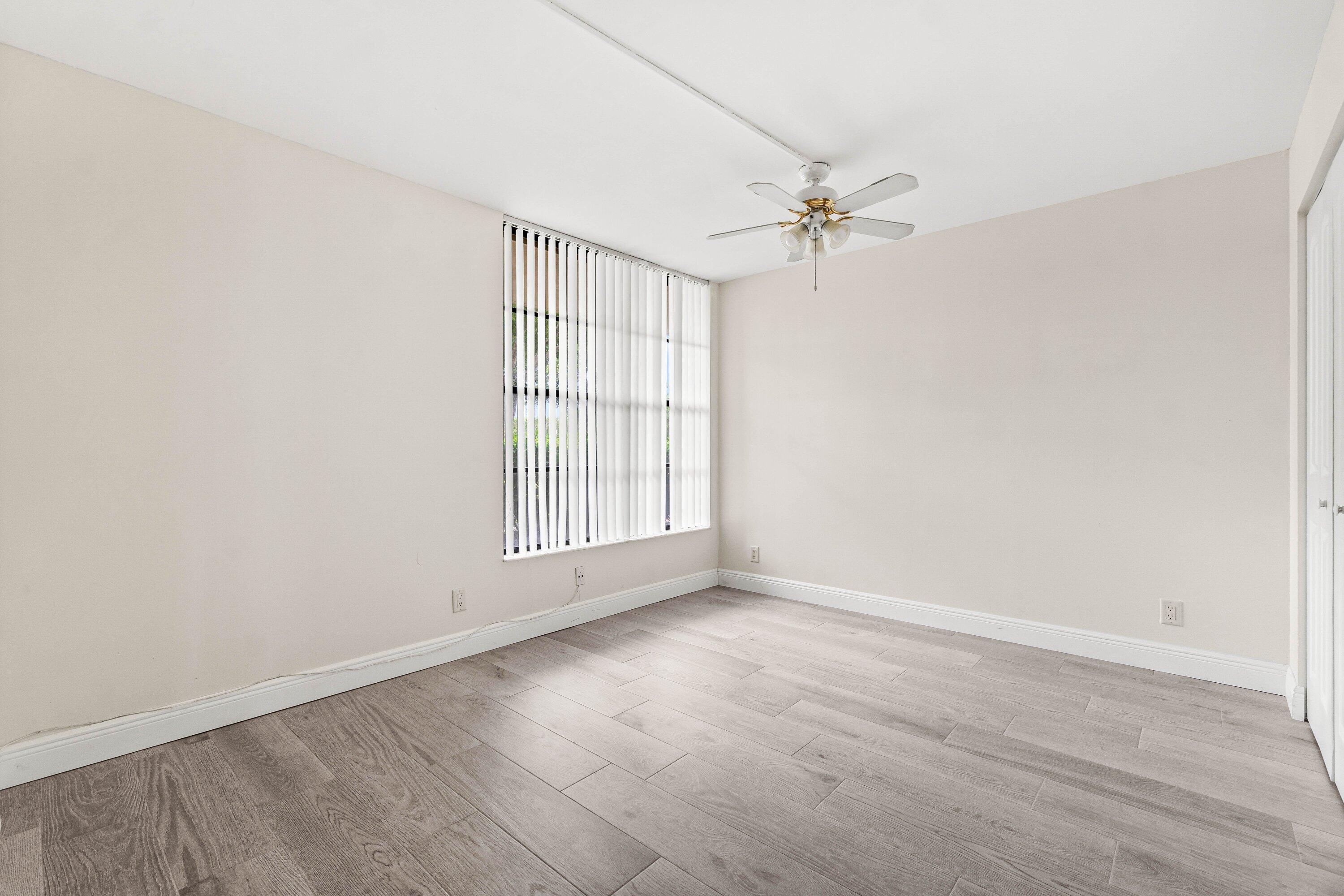 17 Royal Palm Way, Unit 103 Boca Raton, FL 33432 - Photo 23 of 28 an empty room with windows and fan