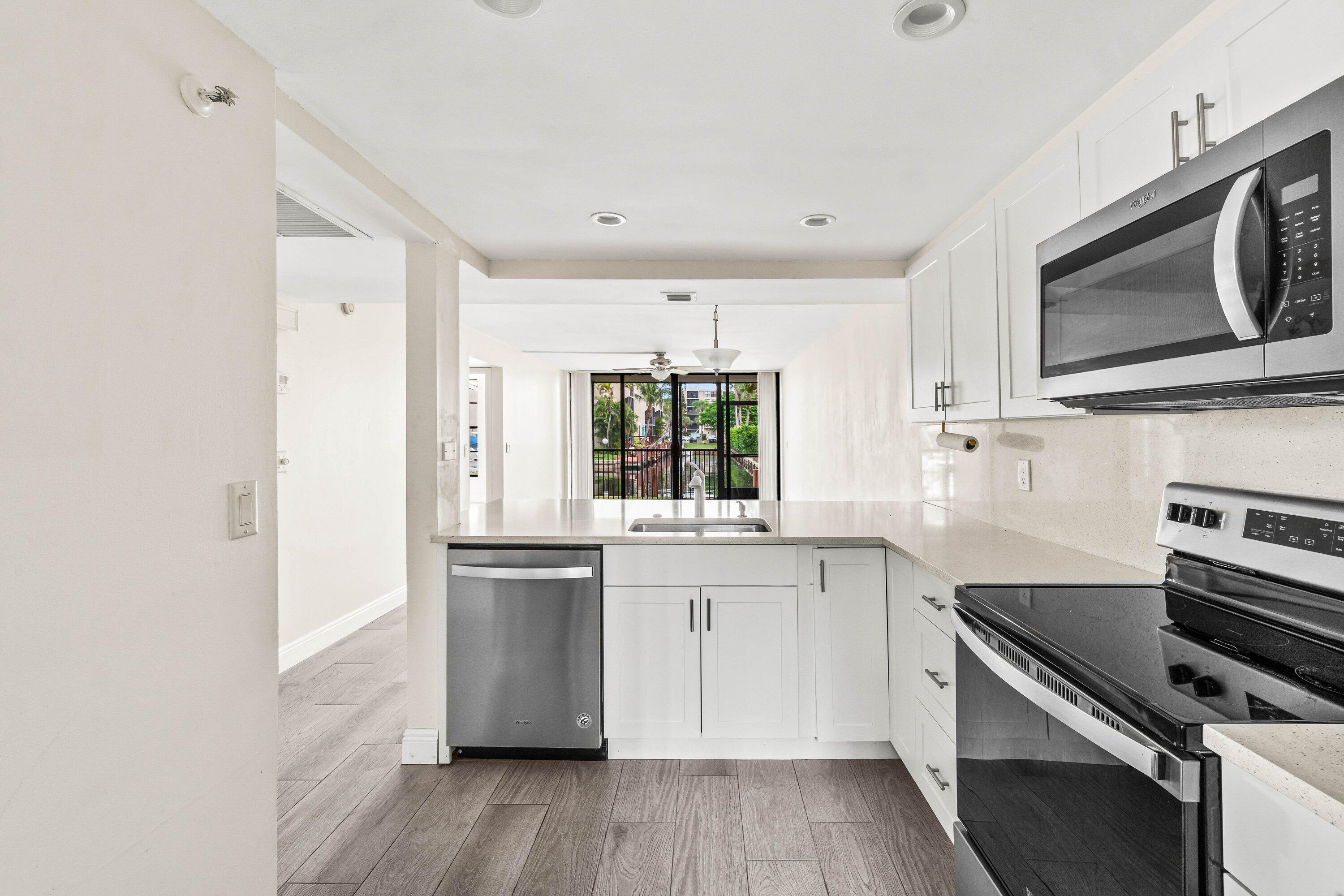 17 Royal Palm Way, Unit 103 Boca Raton, FL 33432 - Photo 5 of 28 a kitchen with stainless steel appliances a stove sink and microwave