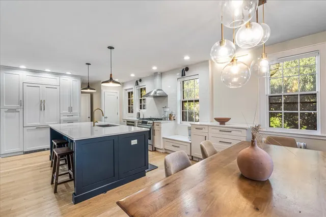 a kitchen with stainless steel appliances granite countertop a sink a stove and a wooden floor
