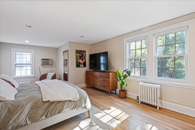 a bedroom with a bed and wooden floor