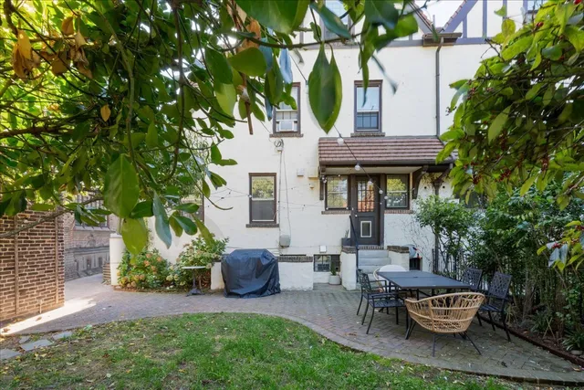 a backyard of a house with barbeque oven table and chairs