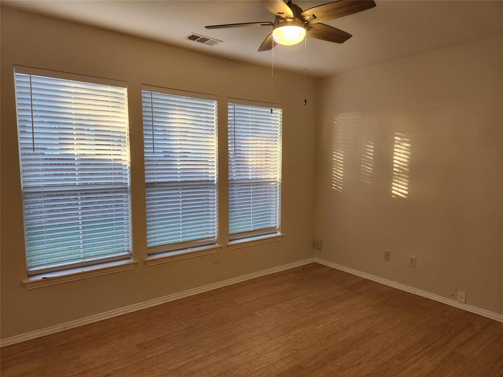 4175 Midrose Trail Dallas, TX 75287 - Photo 7 of 14 Interior space featuring three windows with blinds, wood-finish flooring, a ceiling fan with integrated lighting, and neutral wall tones