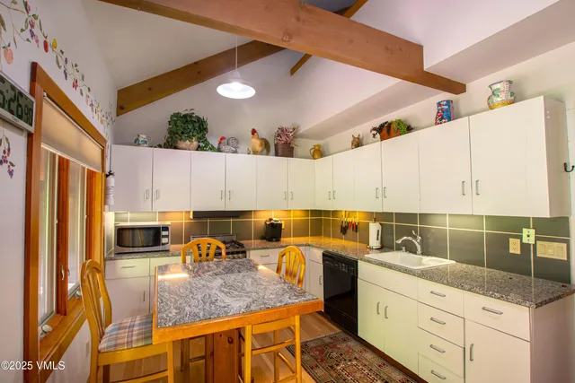 a kitchen with stainless steel appliances granite countertop a sink a stove counter space and cabinets