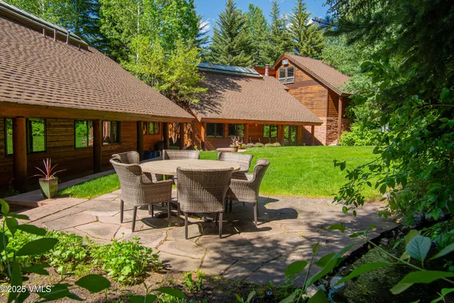 a view of a patio with table and chairs potted plants and large tree