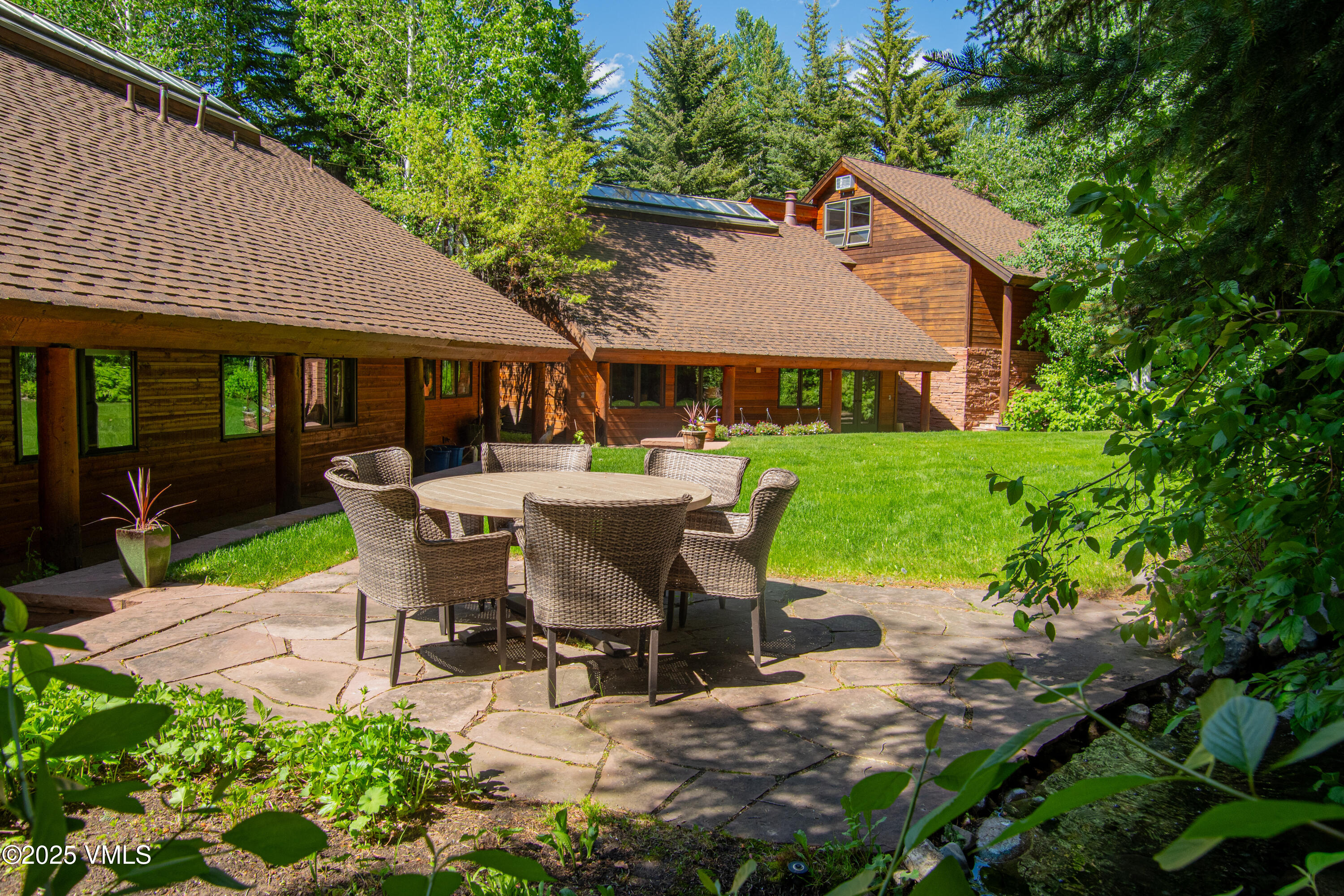 1461 Greenhill Court, Unit A AND B Vail, CO 81657 - Photo 2 of 44 a view of a patio with table and chairs potted plants and large tree