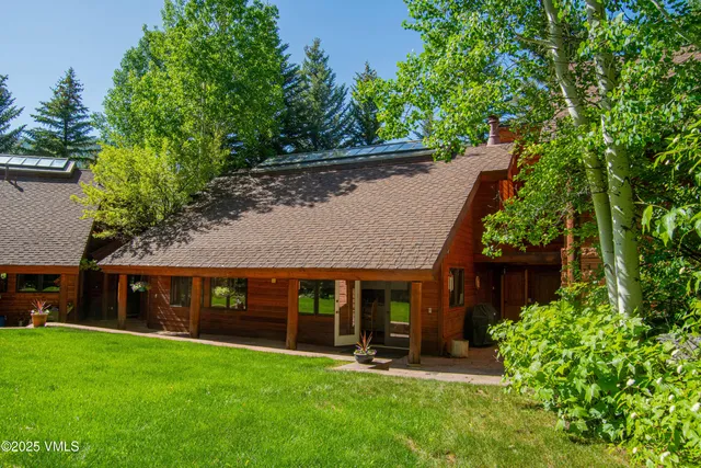 a view of a patio with table and chairs and potted plants with large tree