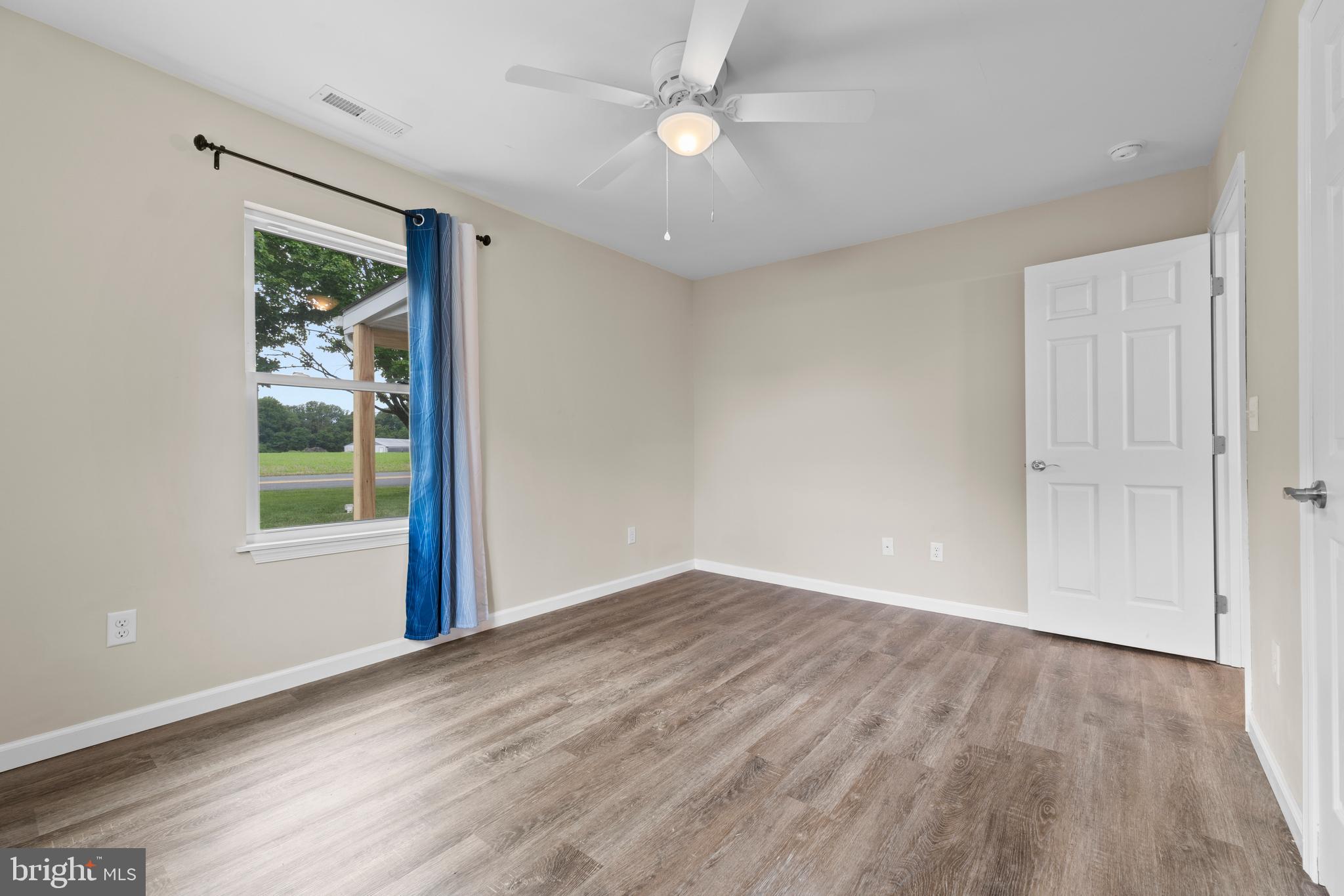 6475 Big Stone Beach Road Milford, DE 19963 - Photo 19 of 52 wooden floor in an empty room with a window