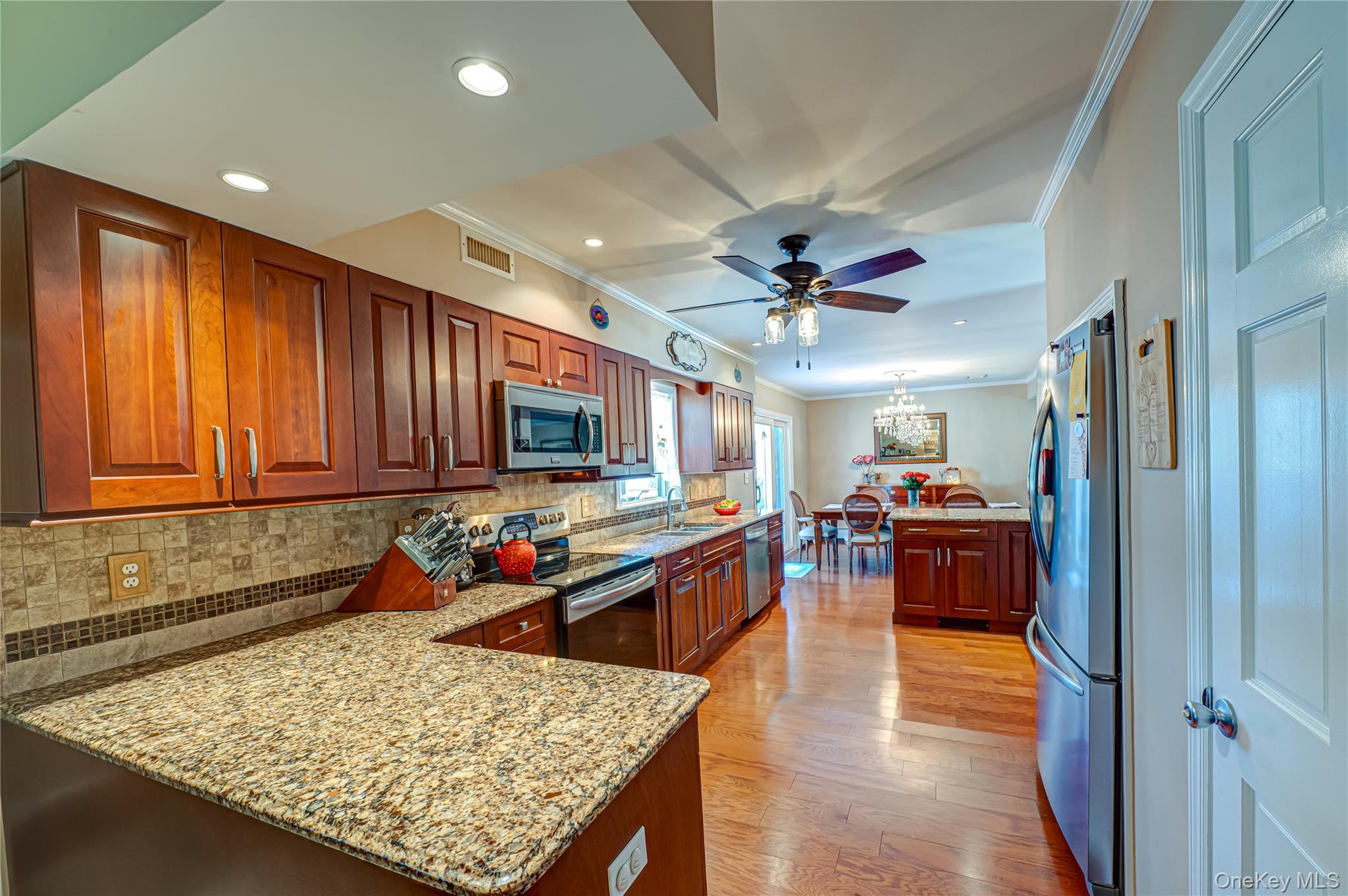 20 Bayview Road Amityville, NY 11701 - Photo 8 of 24 a kitchen with stainless steel appliances granite countertop wooden cabinets a refrigerator and a sink