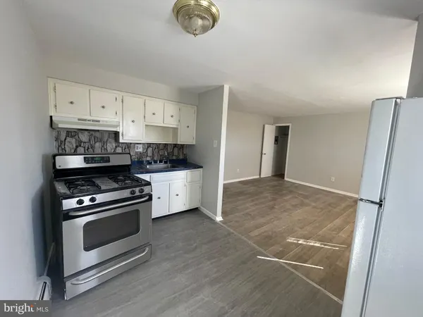 a kitchen with stainless steel appliances a stove a refrigerator and cabinets