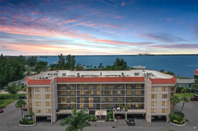 a front view of a building with streets and trees