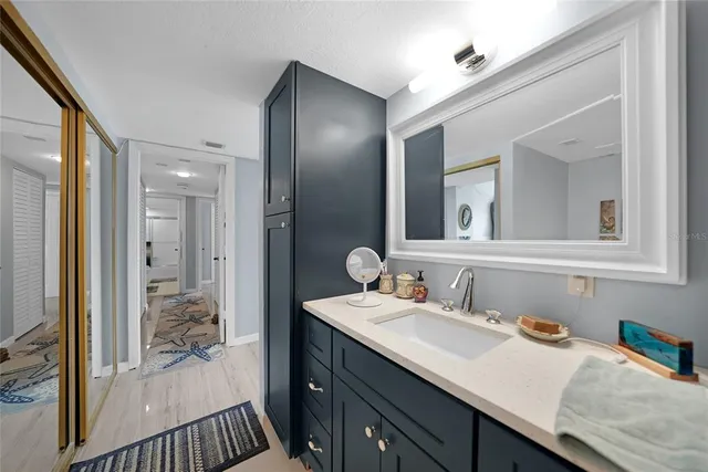 a en suite bathroom with a granite countertop sink and a mirror