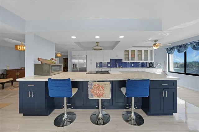 a kitchen with granite countertop a table chairs in it and wooden floors