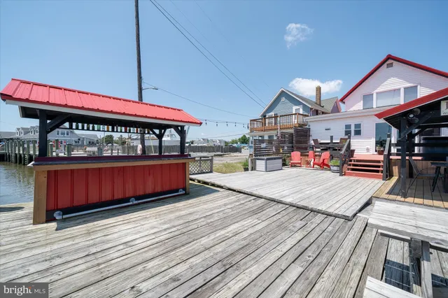 a room with stainless steel appliances kitchen island granite countertop lots of wooden furniture