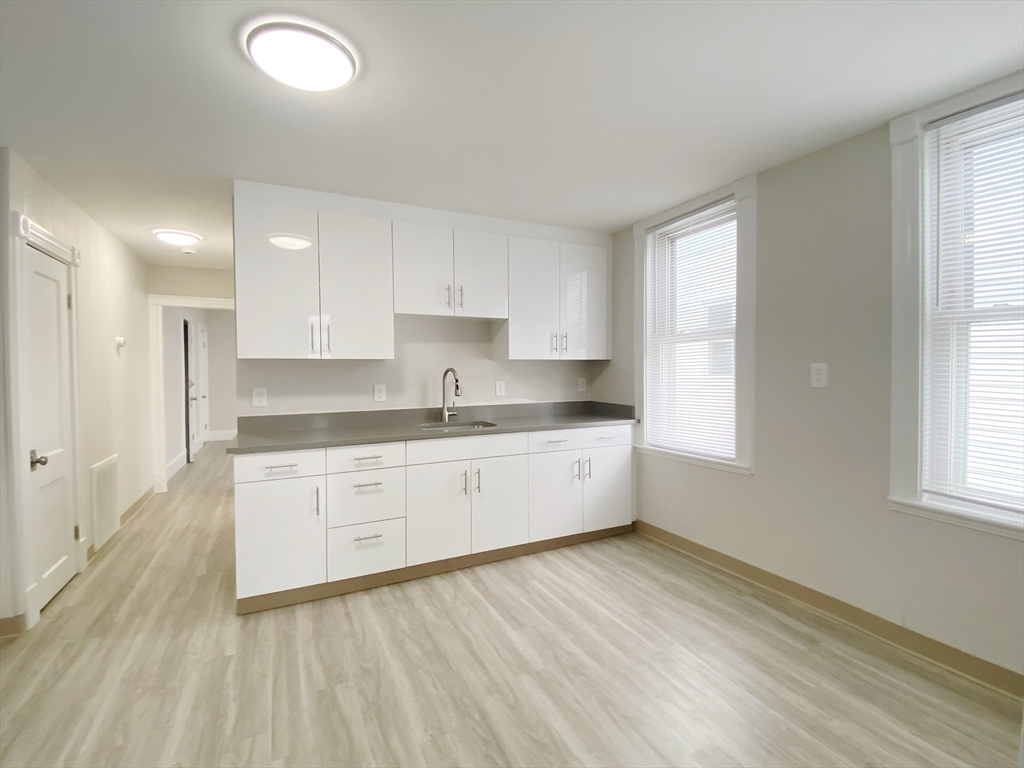 44 Jones Road, Unit 5 Revere, MA 02151 - Photo 6 of 11 a large kitchen with granite countertop a sink window and cabinets