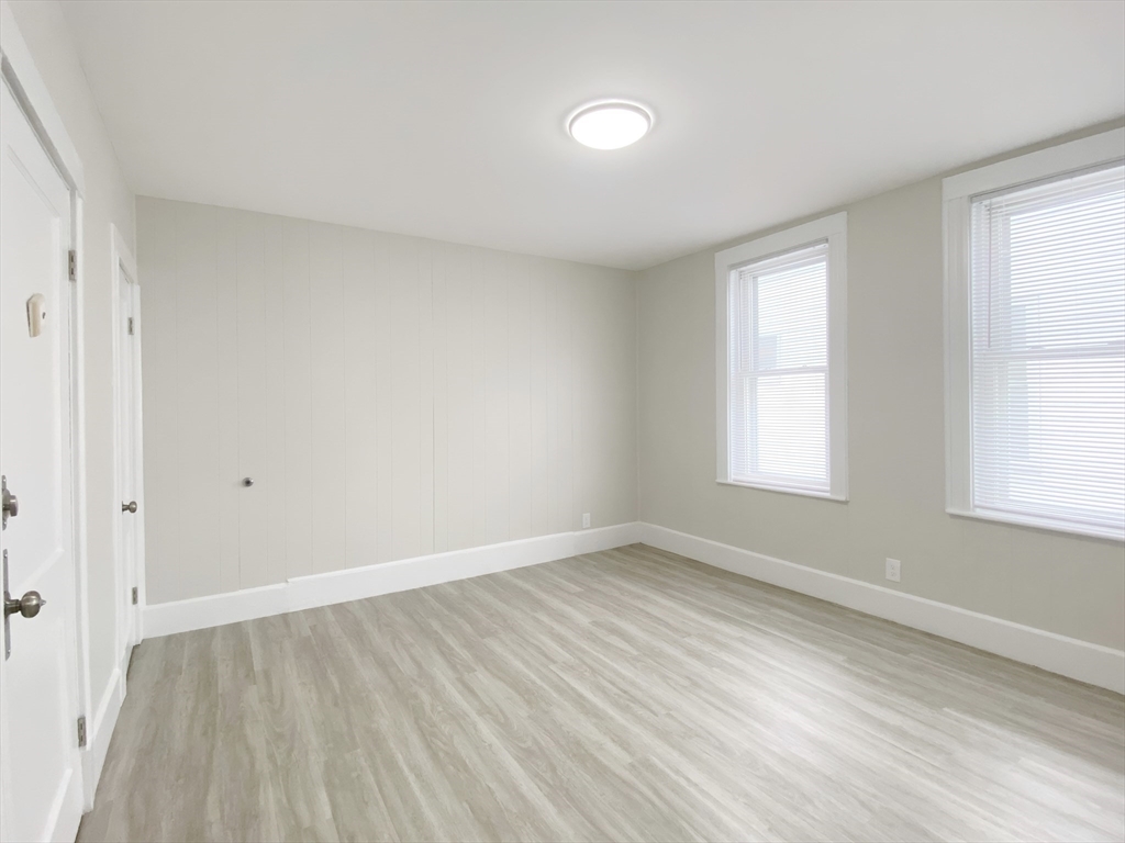 44 Jones Road, Unit 5 Revere, MA 02151 - Photo 8 of 11 an empty room with wooden floor and windows