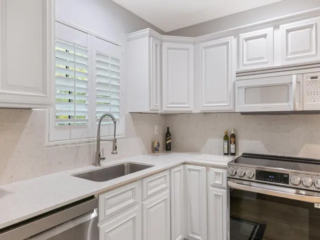 a kitchen with a refrigerator sink and cabinets