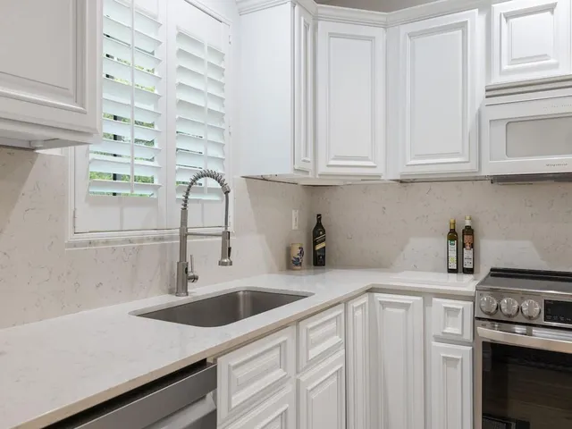 a kitchen with stainless steel appliances granite countertop a refrigerator stove and sink