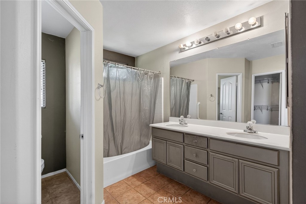 3560 McKinley Street Riverside, CA 92506 - Photo 16 of 45 a bathroom with a double vanity sink a large mirror and a bathtub
