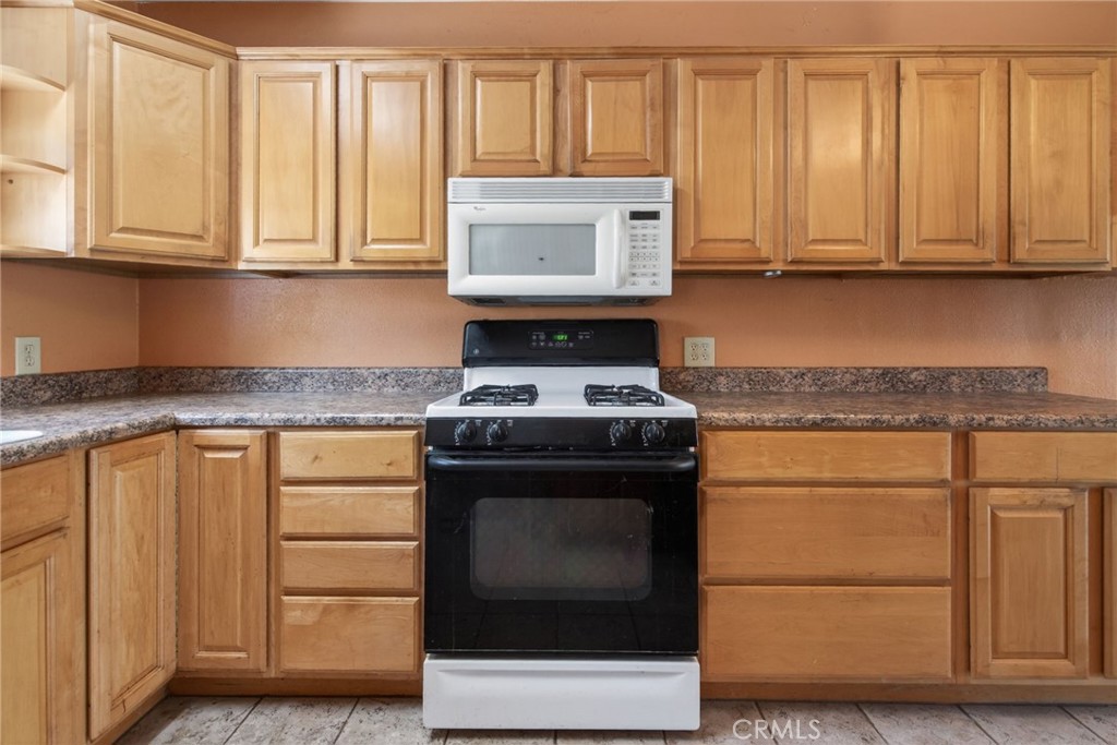 3560 McKinley Street Riverside, CA 92506 - Photo 10 of 45 a kitchen with granite countertop white cabinets and black appliances