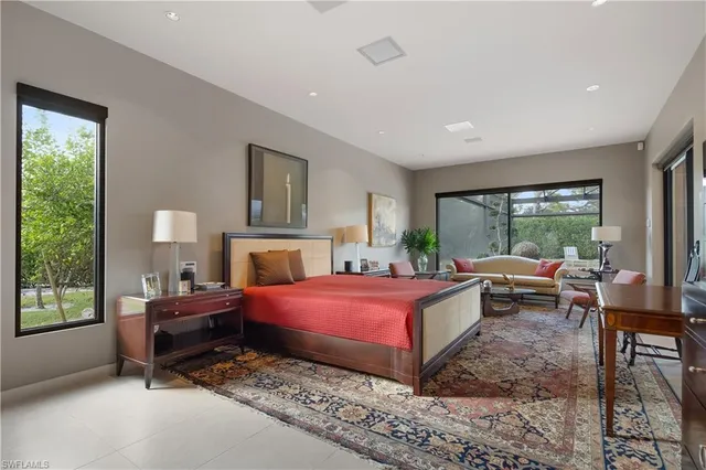 a bedroom with a bed and large window