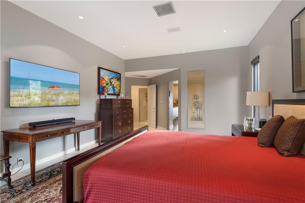 705 Shadow Lake Lane Naples, FL 34108 - Photo 22 of 47 a bedroom with a bed and a flat screen tv