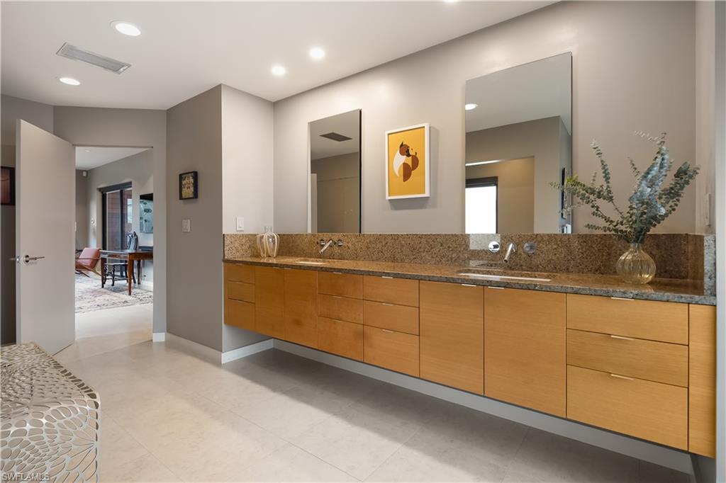 705 Shadow Lake Lane Naples, FL 34108 - Photo 25 of 47 a spacious bathroom with a granite countertop sink and a mirror