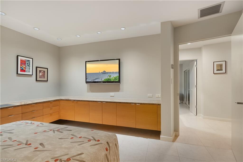 705 Shadow Lake Lane Naples, FL 34108 - Photo 27 of 47 a view of a bedroom with a bed and wooden floor