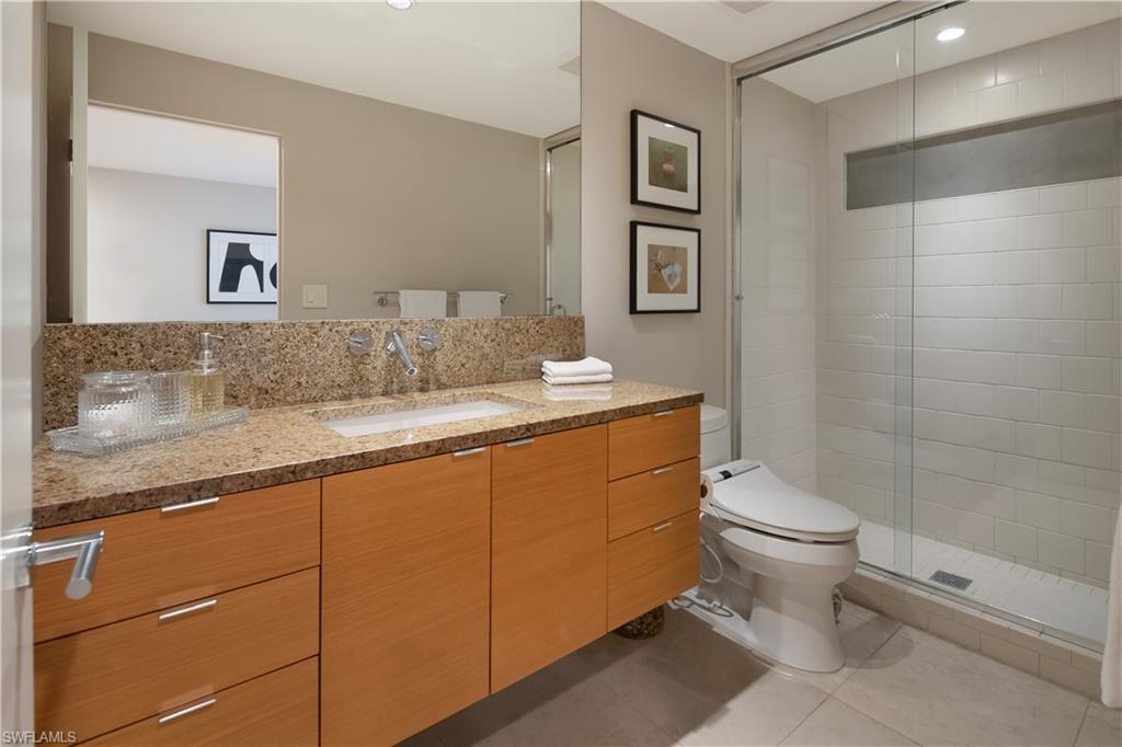 705 Shadow Lake Lane Naples, FL 34108 - Photo 30 of 47 a bathroom with a granite countertop sink toilet and shower