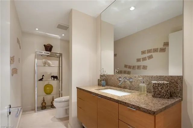 a en suite bathroom with a granite countertop toilet and a sink