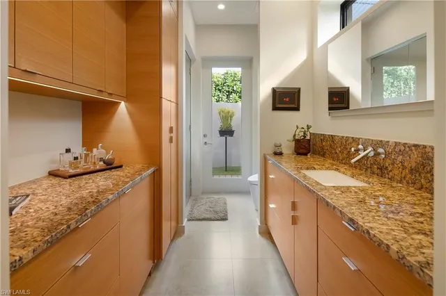 a bathroom with a granite countertop sink and mirror
