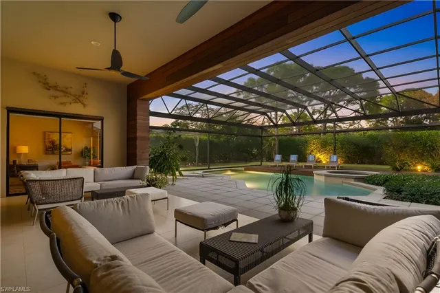 a living room with patio furniture and a potted plant