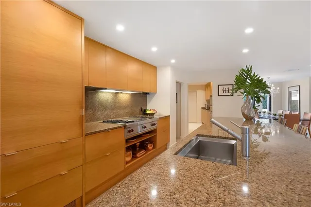 a kitchen with stainless steel appliances a sink a stove and cabinets