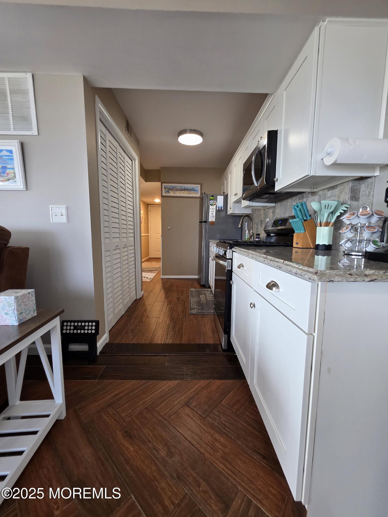 42 Dune Terrace Seaside Heights, NJ 08751 - Photo 7 of 17 a kitchen with stainless steel appliances granite countertop a refrigerator a stove top oven a sink and dishwasher