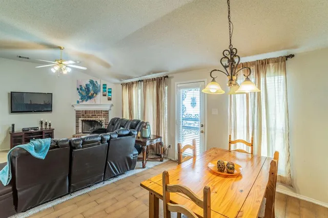 a living room with furniture a fireplace and a chandelier