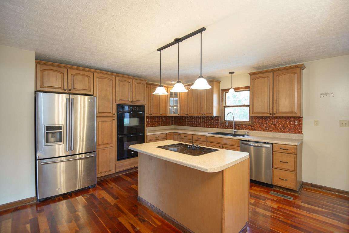 101 Spring Creek Road Waverly, TN 37185 - Photo 2 of 30 Gorgeous Kitchen! Cherry Hardwood Floors, Stainless/Black Appliances, Double Oven, Island with Cooktop