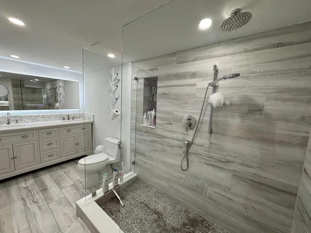 a bathroom with a granite countertop sink a toilet and a mirror