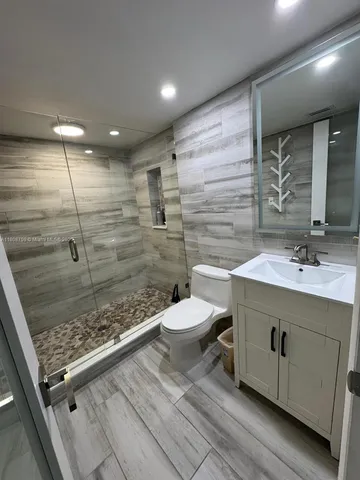 a bathroom with a sink toilet and shower