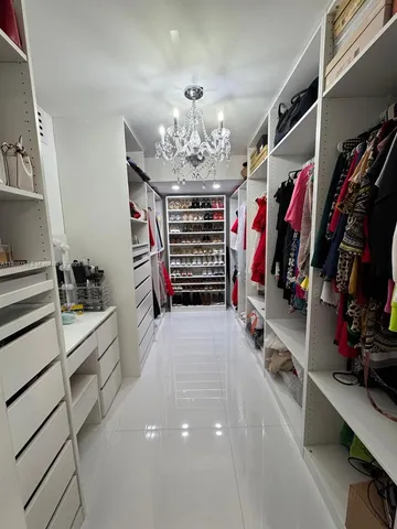 a view of walk in closet with clothes and shoes