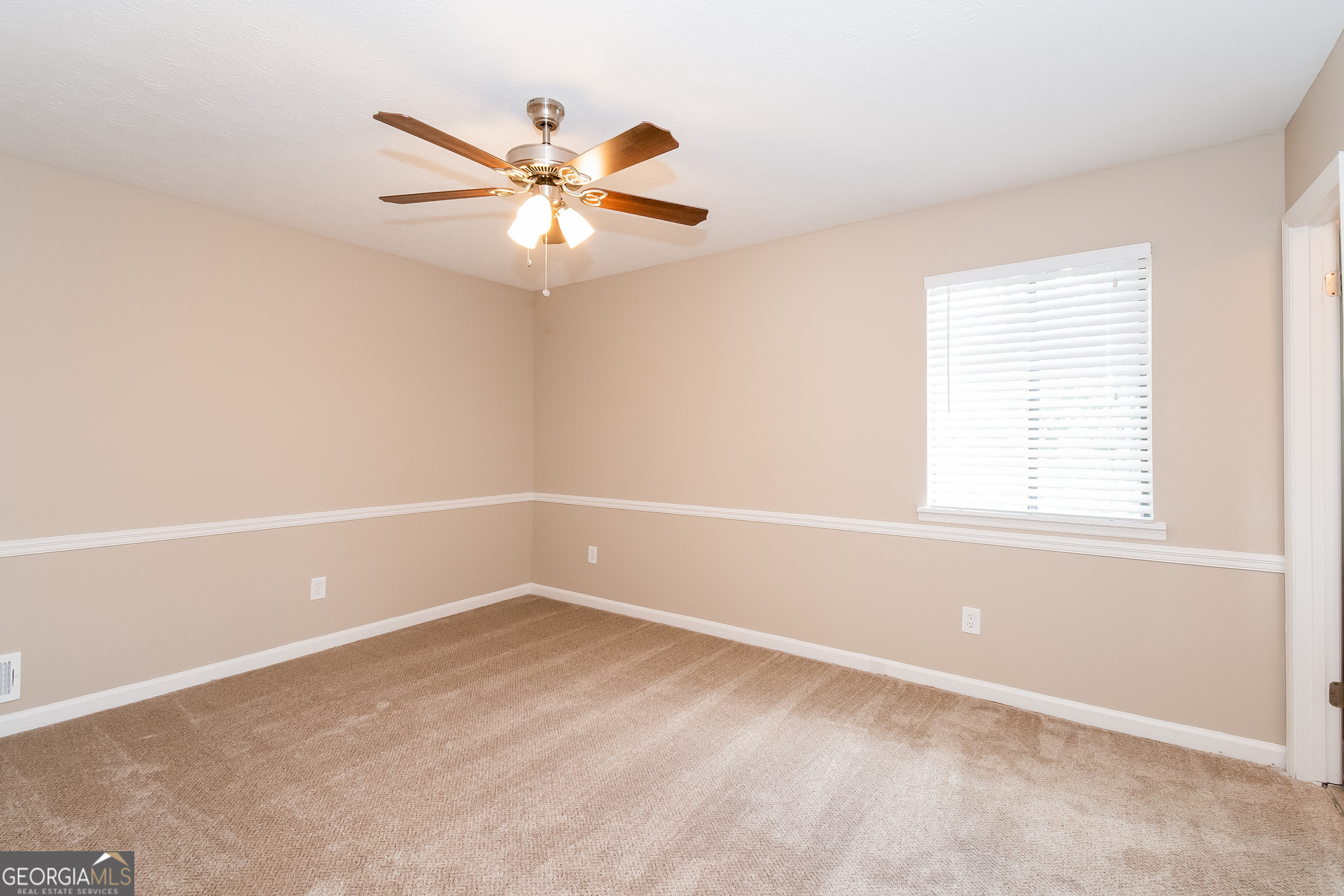 2264 Rocklane Drive Conley, GA 30288 - Photo 3 of 15 an empty room with a window and a fan