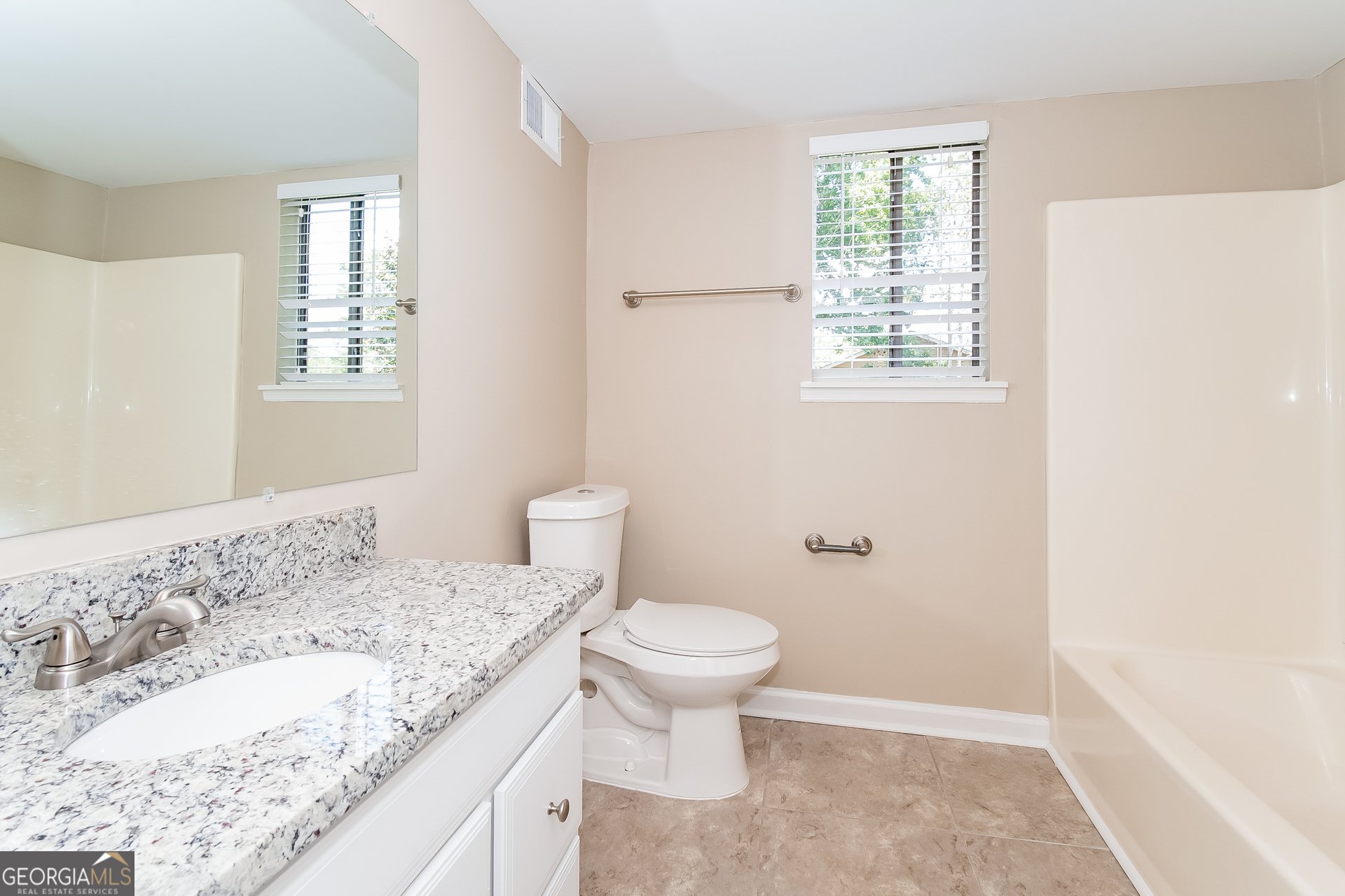 2264 Rocklane Drive Conley, GA 30288 - Photo 8 of 15 a bathroom with a granite countertop sink a toilet and a window