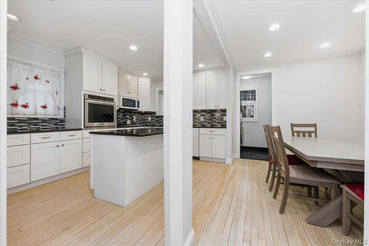 22 Sunset Trail, Unit 22 Bronx, NY 10465 - Photo 5 of 21 a kitchen with stainless steel appliances kitchen island granite countertop a refrigerator a stove a microwave oven a sink with island and chairs