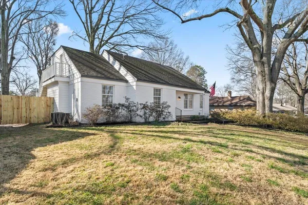 a front view of a house with a garden and trees
