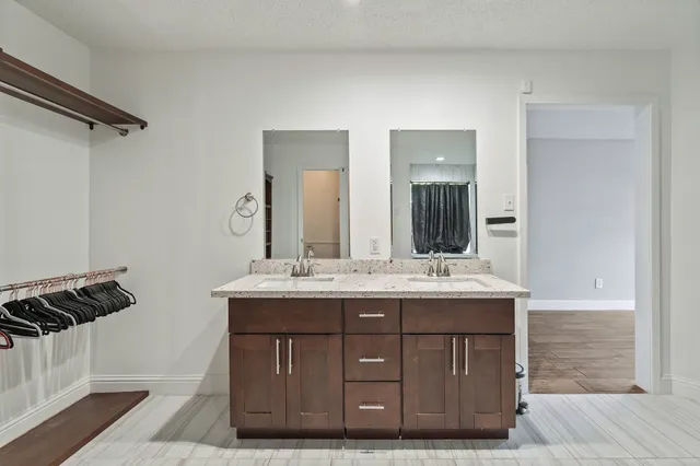 a bathroom with a granite countertop sink and a mirror