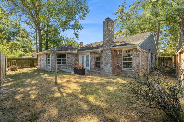 a view of a yard in front of a house with large tree